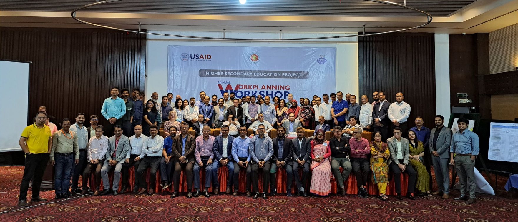 Group photo of teachers, trainers and partner staff at HSEP's annual work-planning workshop in Dhaka, under a USAID Higher Secondary Education Project banner